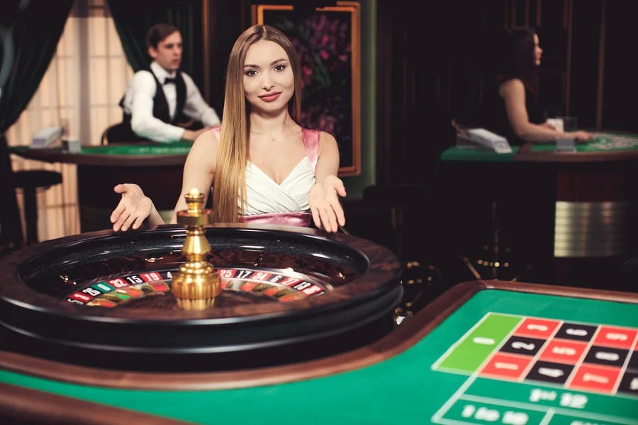 Dealer di meja kasino live dengan panel taruhan digital